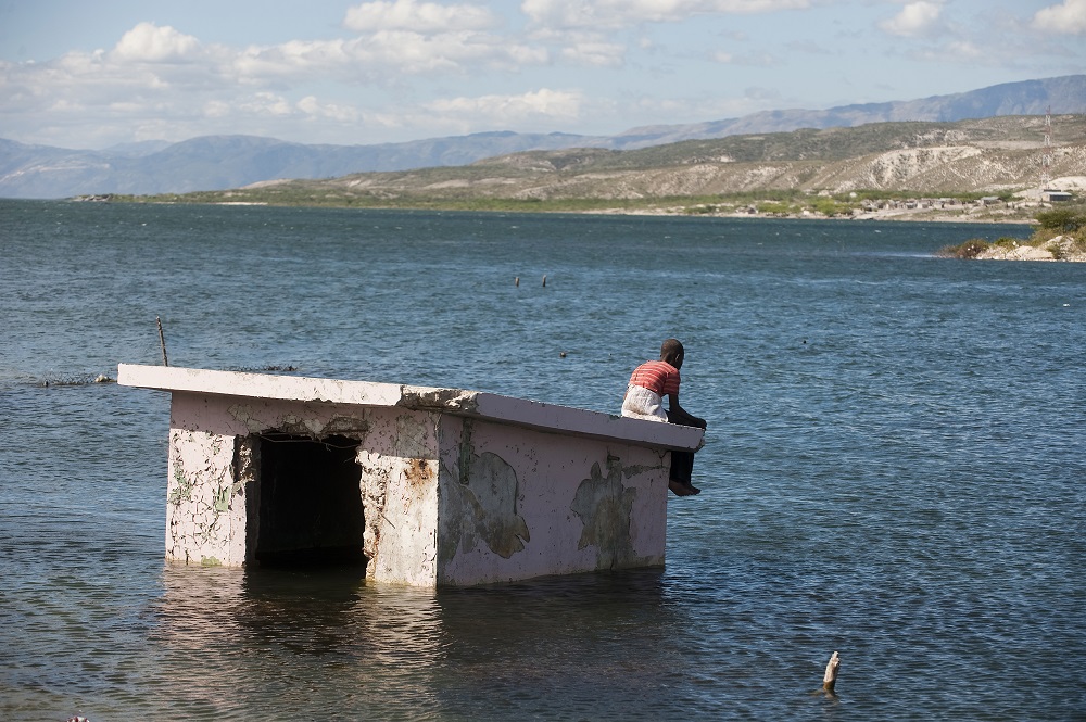 Man sitting on a building surrounded by water